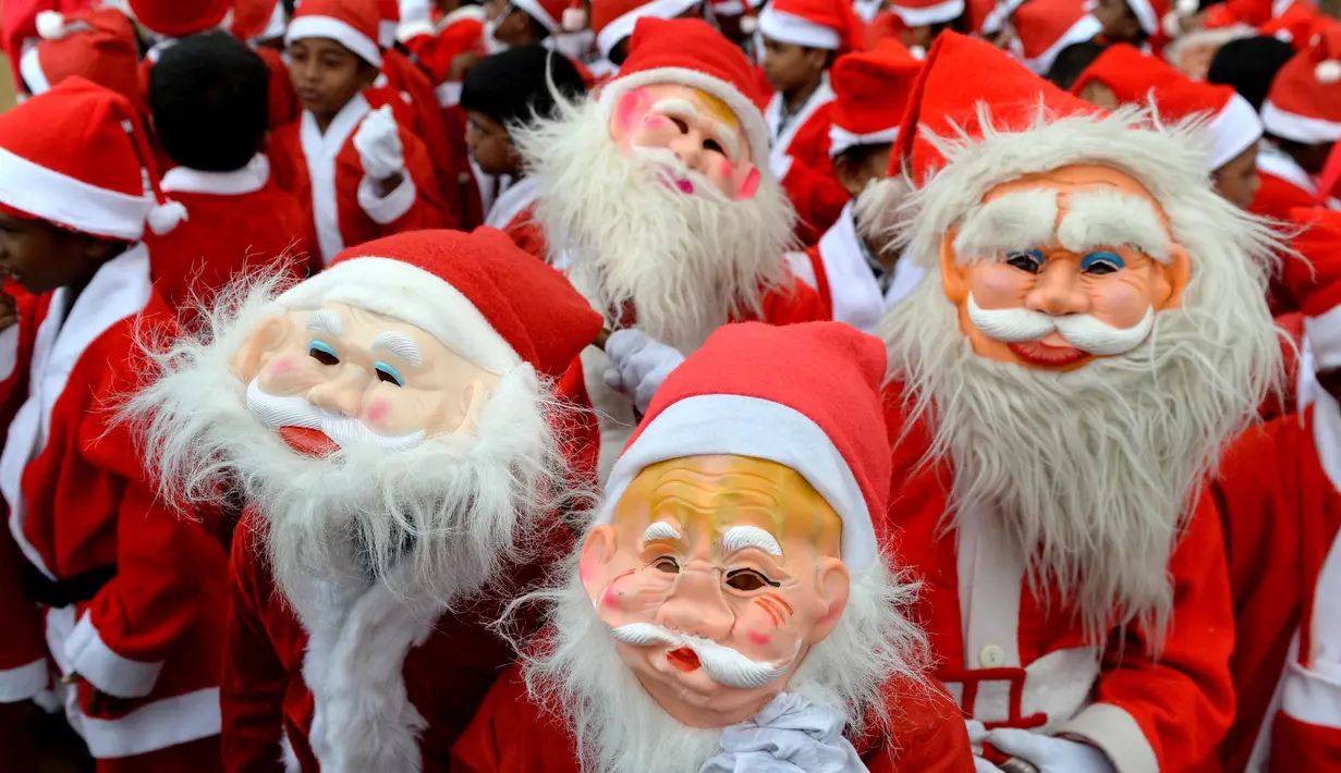 Anak-anak sekolah India mengenakan kostum Santa Claus berpose saat mereka mengambil bagian dalam acara Natal di sebuah sekolah di Chennai, (5/12). Natal adalah hari raya umat Kristen yang diperingati setiap tanggal 25 Desember. (AFP Photo/Arun Sankar)