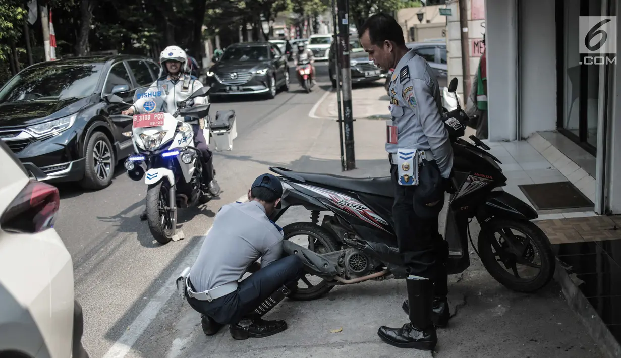 Petugas Dishub DKI Jakarta merazia  kendaraan roda dua dengan mencopot pentil yang terparkir di trotoar di kawasan Cipete Raya, Jakarta, Selasa (13/8/2019). Razia tersebut dilakukan Dishub untuk mengembalikan fungsi trotoar