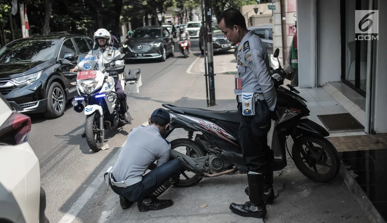 Petugas Dishub DKI Jakarta merazia  kendaraan roda dua dengan mencopot pentil yang terparkir di trotoar di kawasan Cipete Raya, Jakarta, Selasa (13/8/2019). Razia tersebut dilakukan Dishub untuk mengembalikan fungsi trotoar