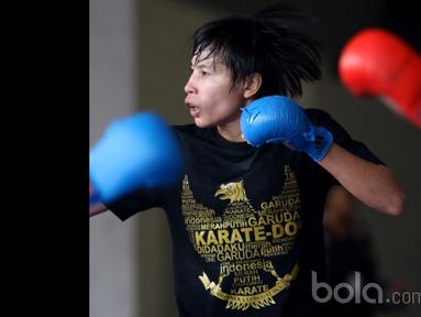 Seorang Karateka Putri dengan kaos bergambar garuda tengah berlatih mematangkan pukulan di Senayan, Jakarta, (Bola.com/Nicklas Hanoatubun)
