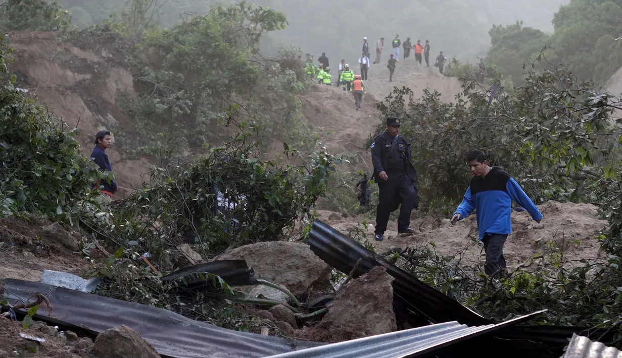 Polisi dan penduduk setempat menyisir lokasi tanah longsor saat mencari korban di Santa Catarina Pinula, Guatemala (2/10/2015). Penyelamatan dan pencarian personil terus bekerja di daerah sampai saat ini. (REUTERS/Josue Decavele)