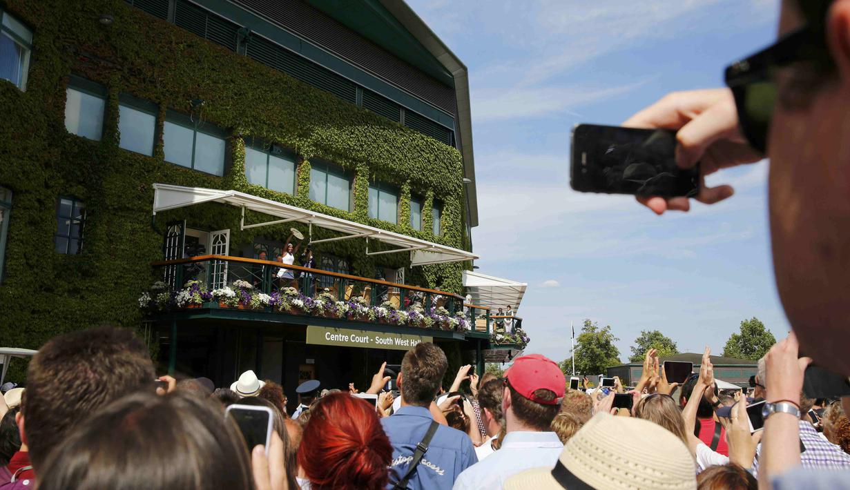 Serena Williams memamerkan trofi Wimbledon kepada para penggemar dari balkon Center Court. (REUTERS/Stefan Wermuth)