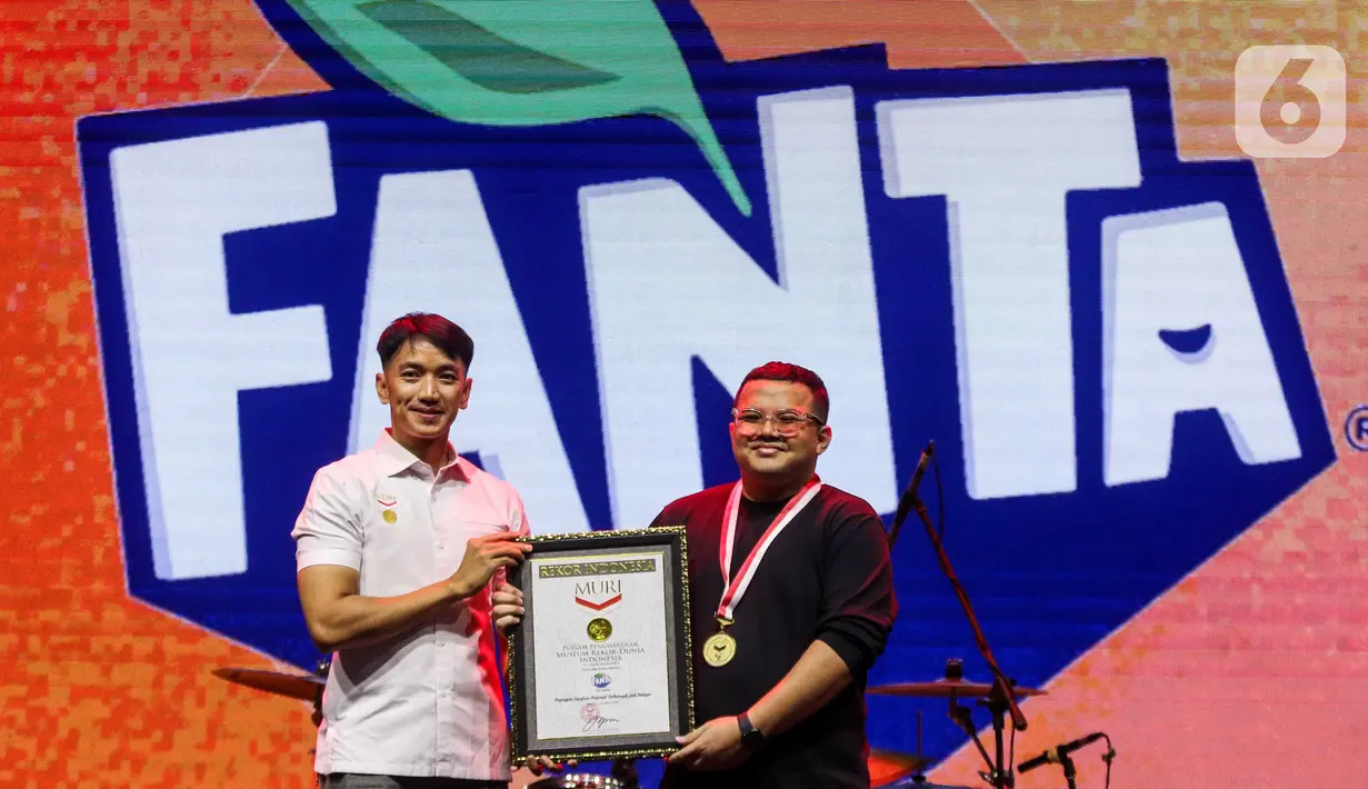 Senior Manager Museum Rekor Indonesia (MURI), Triyono (kiri) menyerahkan piagam ke Frontline Brand Manager The Coca-Cola Company Muhammad Maulana Soesetyo saat acara KapanLagi Pensi Bareng Fanta 2025 di Gelanggang Olahraga (GOR) atau Gelanggang Mahasiswa Soemantri Brodjonegoro, Jakarta, Sabtu (28/6/2025). (Liputan6.com/Herman Zakharia)