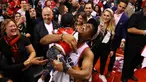 Pebasket Toronto Raptors, Kyle Lowry, menggendong putranya usai mengalahkan Milwaukee Bucks pada NBA Final Wilayah Timur di Scotiabank Arena, Toronto, Sabtu (25/5). Raptors menang 4-2 atas Bucks. (AFP/Gregory Shamus)