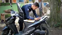 Petugas Samsat melakukan cek fisik terhadap kendaraan milik warga. Hal ini merupakan terobosan terbaru Samsat Polda Tangerang dengan cara mendatangi wajib pajak. (Antara)