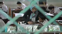 Sejumlah murid SDN 04 Jakarta, mengerjakan soal Ujian Nasional (UN), Senin (18/5/2015). Sebanyak 153.266 peserta didik SD, Madrasah Ibtidaiyah (MI) dan sederajat di Jakarta mengikuti UN yang digelar 18-20 Mei. (Liputan6.com/Herman Zakharia)