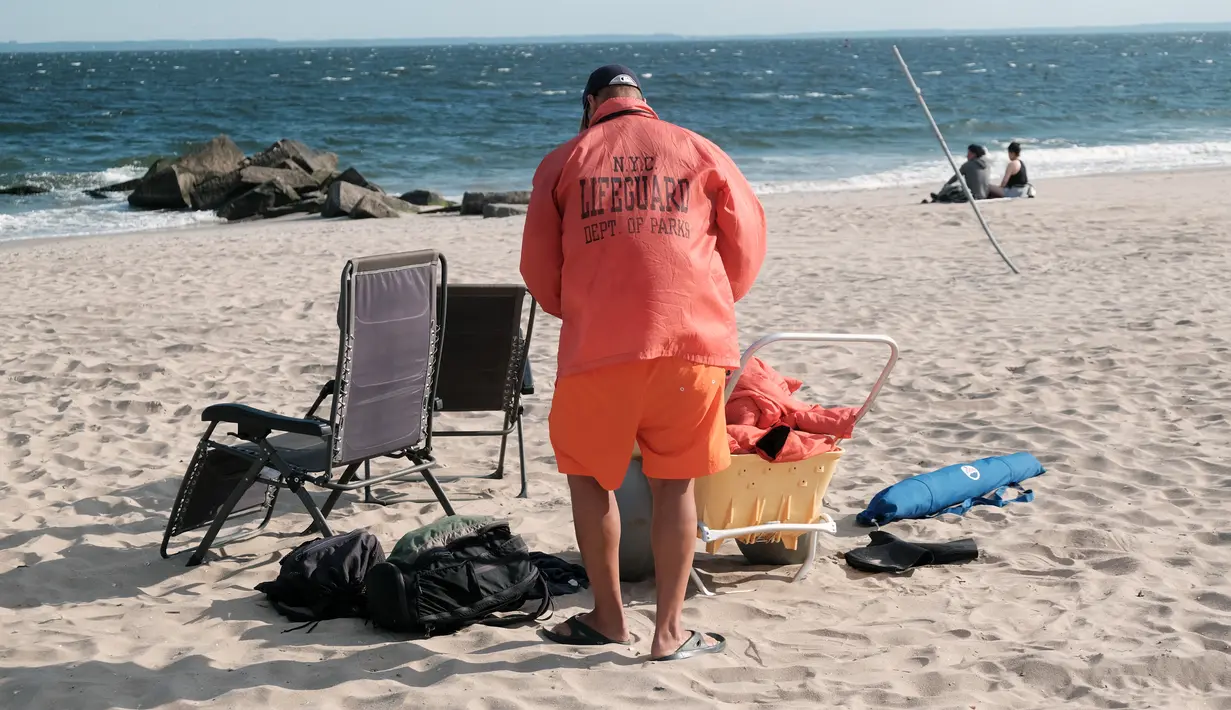 Penjaga pantai berjaga di Coney Island, salah satu tujuan pantai paling populer di wilayah Brooklyn di New York City (29/6/2022). Menyusul tenggelamnya dua pemuda di Rockaway dua minggu lalu, Gubernur Kathy Hochul menaikkan gaji penjaga pantai untuk menarik lebih banyak pelamar ke pantai negara bagian. (Spencer Platt/Getty Images/AFP)