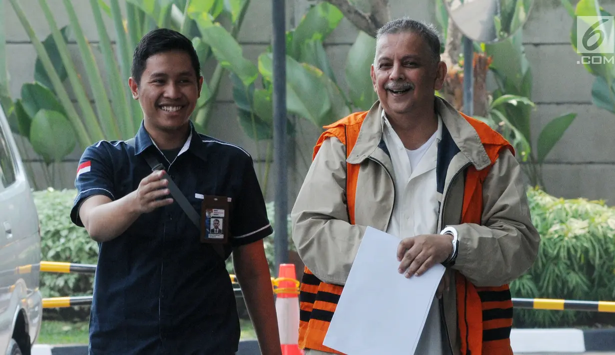 Direktur Utama nonaktif PLN Sofyan Basir (kanan) tiba di Gedung KPK, Jakarta, Kamis (27/6/2019). Sofyan berjalan menuju lobi KPK dengan memakai rompi tahanan dan tangan terborgol, tetapi dia terlihat menutupinya dengan lembaran kertas. (merdeka.com/Dwi Narwoko)