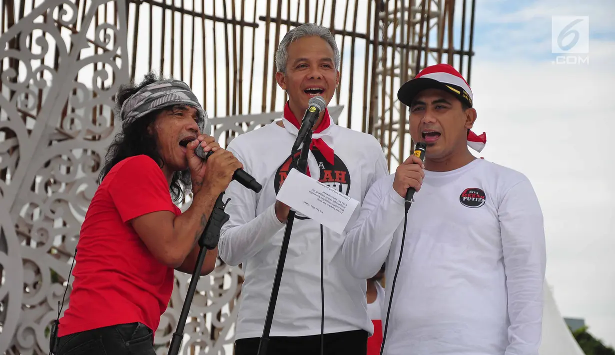Grup band musik Slank duet dengan Gubernur Jawa Tengah, Ganjar Pranowo saat memeriahkan Apel Kebangsaan 'Kita Merah Putih' di lapangan Pancasila Simpang Lima Semarang, Minggu (17/3). (Liputan6.com/Gholib)