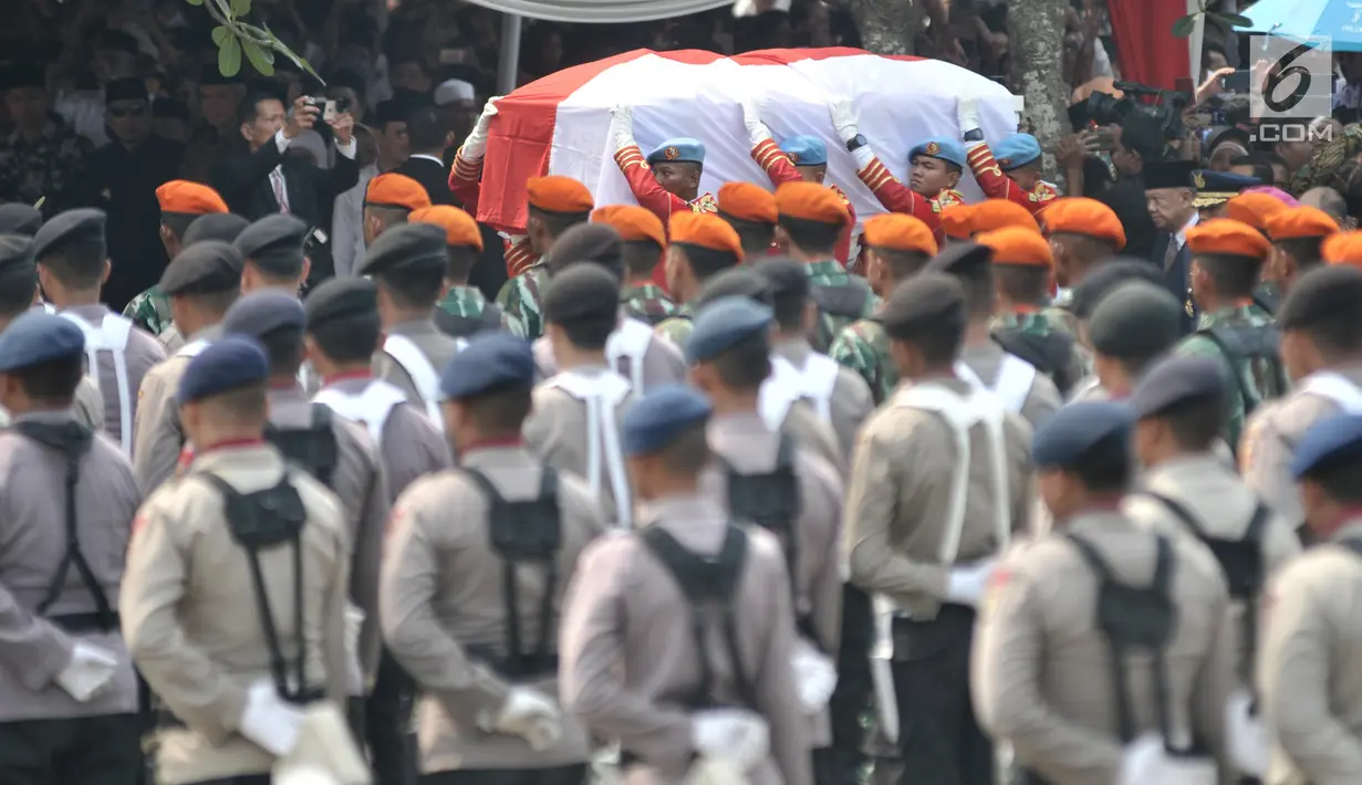 Paspampres mengusung peti jenazah almarhum Presiden ke-3 RI BJ Habibie menuju liang lahat saat tiba di TMP Kalibata, Jakarta, Kamis (12/9/2019). Dimakamkan secara militer, jenazah BJ Habibie diiringi derap marching band dan lantunan kalimat tahlil dari para pelayat. (merdeka.com/Iqbal Nugroho)