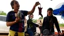 Seorang wanita saat membeli tikus bakar di sebuah kios di provinsi Battambang, Kamboja (8/8/2019). Tikus bakar yang tusuk sate harganya masing-masing 0,25 USD atau sekitar 3500 rupiah. (AFP Photo/Tang Chhin Sotthy)