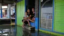 Jaka Sadewa (kanan), istrinya Sri Wahyuni, dan putranya Bima berfoto di Timbulsloko, Jawa Tengah, Indonesia, 31 Juli 2022. "Saya khawatir setiap tahun airnya akan semakin tinggi. Tapi kami tidak punya sumber daya," katanya. "Jika kami memiliki sumber daya, kami akan pindah." (AP Photo/Dita Alangkara)