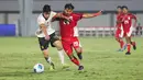 Pemain Timnas Indonesia U-17, I Komang Semadi berduel dengan pemain China U-17, Li Junpeng dalam pertandingan uji coba internasional di Indomilk Arena, Tangerang, pada Rabu (11/2/2026) malam WIB. (Bola.com/Abdul Aziz)