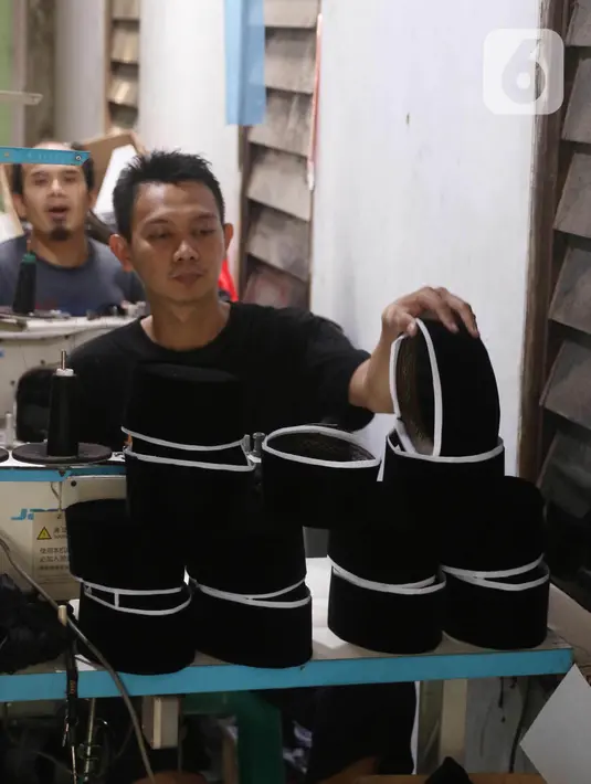Pengrajin songkok (peci) sedang mengerjakan pesanan berbagai jenis peci di  Pasar Kemis, Kabupaten Tangerang, Banten, Minggu (18/4/2021). Pesanan songkok bermerk Bulan Bintang Mas Haji Sanusi mengalami peningkatan  pada bulan puasa. (Liputan6.com/Angga Yuniar)