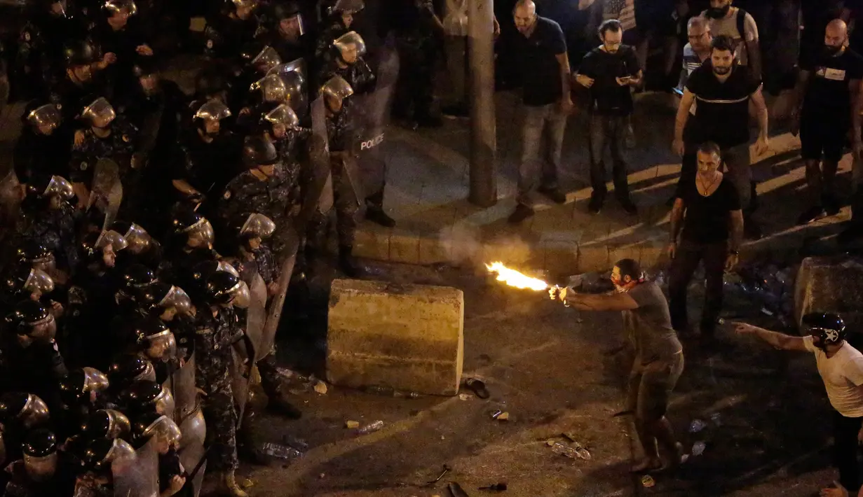 Polisi menghalau pengunjuk rasa antipemerintah dalam protes menentang rencana pengenaan pajak baru di Beirut, Lebanon, Jumat (18/10/2019). Protes meletus ketika pemerintah berencana mengenakan pajak baru di tengah krisis ekonomi di negeri tersebut. (AP Photo/Hassan Ammar)
