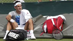 Petenis Swis, Roger Federer bersantai sejenak usai mengikuti sesi latihan di Wimbledon tennis club, London, (1/7/2017). Turnament Wimbledon 2017 akan berlangsung pada  3-16 Juli 2017. (AFP/Adrian Dennis)