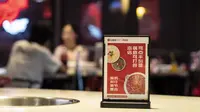 Sebuah pemberitahuan yang mempromosikan pengurangan limbah makanan diletakkan di atas meja restoran hot pot di Chengdu, Provinsi Sichuan, China, 7 September 2020. Banyak restoran hot pot di Chengdu mengampanyekan untuk mengurangi limbah makanan. (Xinhua/Li Mengxin)