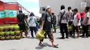 Warga membawa tabung gas elpiji 3 kg saat operasi pasar elpiji di SPBU Ki Hajar Dewantara di Palu, Sulawesi Tengah, Senin (8/10). Pertamina melakukan operasi pasar elpiji 3 kg dan 12 kg yang dijaga aparat polisi dan TNI. (Liputan6.com/Fery Pradolo)