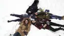 Para wanita berbaring di salju ketika di sebuah taman di Teheran utara, Iran (19/1/2020). Salju tebal menutupi jalan-jalan Teheran, menyebabkan penundaan penerbangan dan munutup sekolah, kata pihak berwenang di ibukota Iran. (AP Photo / Vahid Salemi)