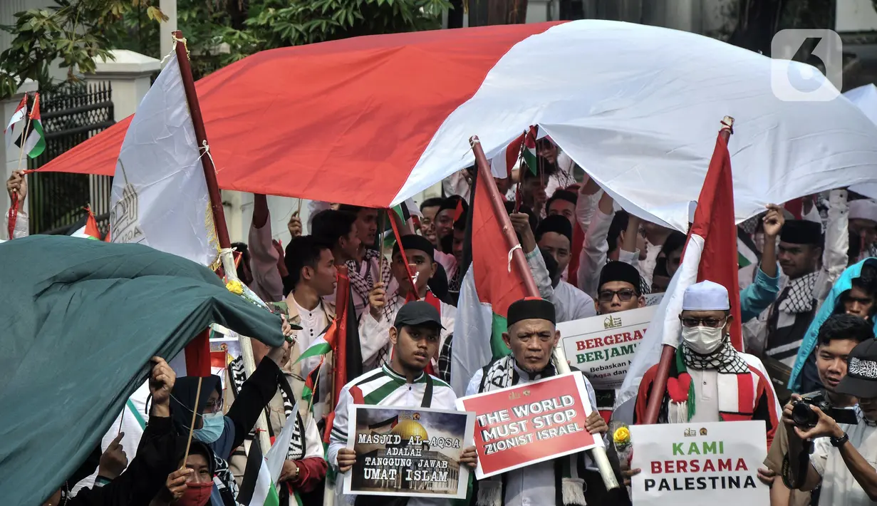 Dalam aksinya, massa menggelar upacara pengibaran bendera Indonesia dan Palestina sebagai simbol solidaritas antarkedua negara. (merdeka.com/Iqbal S. Nugroho)