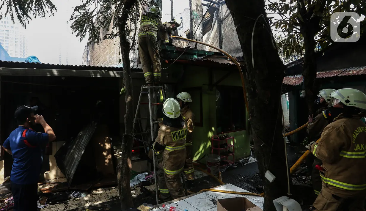 Petugas pemadam kebakaran melakukan proses pendinginan pada permukiman penduduk yang terbakar di Jalan Masjid Alhuda atau depan Stasiun Kebayoran Lama RT 05/01, Jakarta Selatan, Selasa (24/5/2022). Petugas pun mengerahkan 27 unit mobil pemadam kebakaran dari Sudin Damkar Jakarta Selatan ke lokasi kejadian. (Liputan6.com/Johan Tallo)