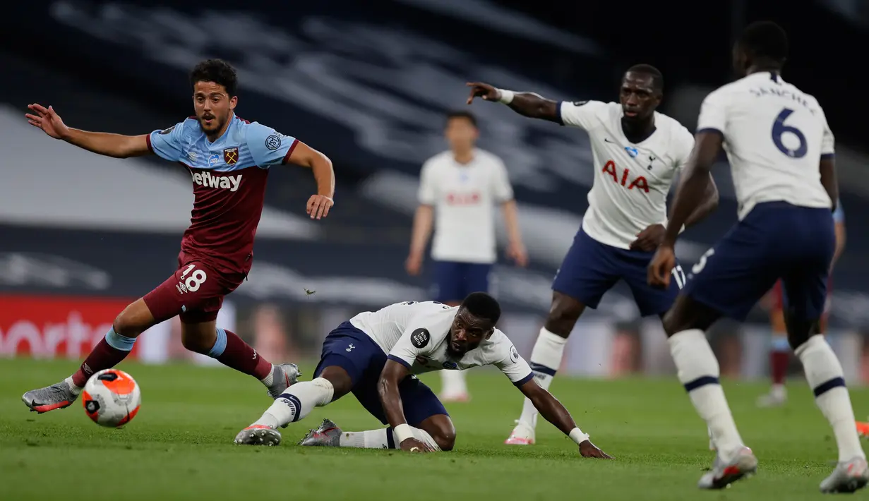 Gelandang West Ham United, Pablo Fornals (kiri) berusaha melewati bek Tottenham Hotspur, Serge Aurier pada pertandingan lanjutan Liga Inggris di Stadion Tottenham Hotspur di London (23/6/2020). Tottenham menang 2-0 atas West Ham. (AFP/Pool/Kirsty Wigglesworth)