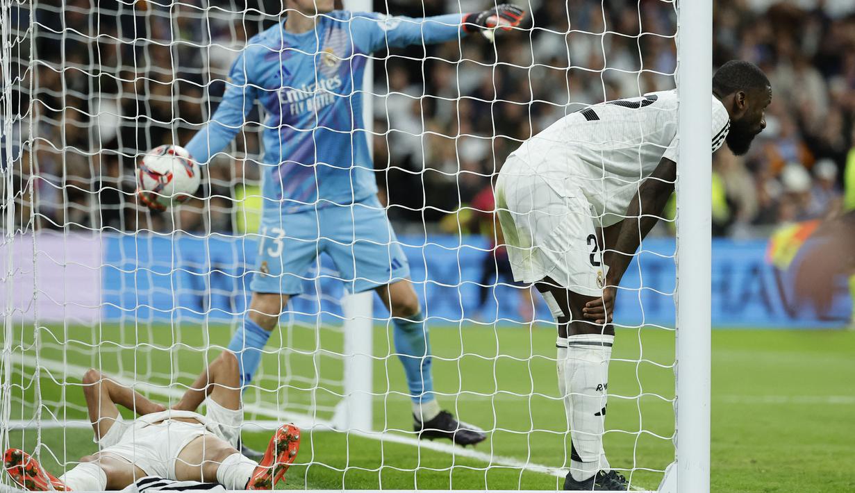 Ekspresi kecewa pemain Real Madrid, Antonio Rudiger (kanan), Andriy Lunin (tengah), dan Lucas Vazquez (kiri) setelah kebobolan oleh pemain Barcelona saat laga lanjutan Liga Spanyol 2024/2025 di Santiago Bernabeu, Madrid, Spanyol, Minggu (27/10/2024) WIB. (AFP/Oscar Del Pozo)