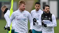 Gelandang Manchester City, Kevin De Bruyne (kiri) dan Bernardo Silva (kanan) berbincang selama sesi latihan di Manchester, Inggris (4/4/2022). Man City akan bertanding melawan Atletico Madrid pada leg pertama perempat final Liga Champions di Etihad Stadium. (AFP/Paul Ellis)