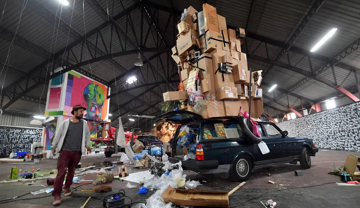 Seorang pria berdiri di dekat sebuah karya seni jalanan oleh kolektif seniman yang ditampilkan Iretge sebagai bagian dari pameran "Strokar inside" di bekas supermarket di Brussels (5/9). (AFP Photo/Emmanuel Dunand)