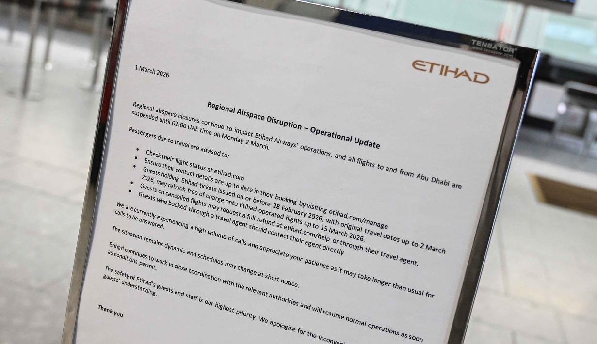 Negara tersebut meliputi Iran, Israel, Irak, Yordania, Qatar, Bahrain, Kuwait, dan Uni Emirat Arab. Tampak dalam foto, sebuah pemberitahuan tentang gangguan penerbangan terlihat di konter check-in yang ditutup untuk maskapai penerbangan Etihad di Bandara Heathrow, London pada Minggu 1 Maret 2026. (JUSTIN TALLIS/AFP)