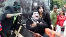 Sejumlah warga berkostum karakter TV "The Munsters," berpose dalam acara Hari Malas Sedunia di Ibague, Kolombia, (14/8). Peti mati sebagai pengganti tempat tidur di Hari Malas Sedunia. (REUTERS/Fredy Builes)