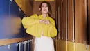 <p>Workwear dengan nuansa yang lebih kasual ala Raisa ini juga bisa ditiru. Dengan long dress putih polos, Raisa menambahkan cropped jacket bewarna kuning tua yang kontras, namun menarik, disempurnakan lagi dengan sneakers favorit. Foto: Instagram.</p>