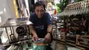 Perajin, Inoe Farhand melakukan finishing pengerjaan pembuatan miniatur jam dari pelepah pisang di Pamulang, Tangerang Selatan, Kamis (10/1). Kerajinan tangan Inoe hasilnya dijual ke sejumlah wiliyah JODETABEK hingga mancanegara. (Merdeka.com/Arie Basuki)