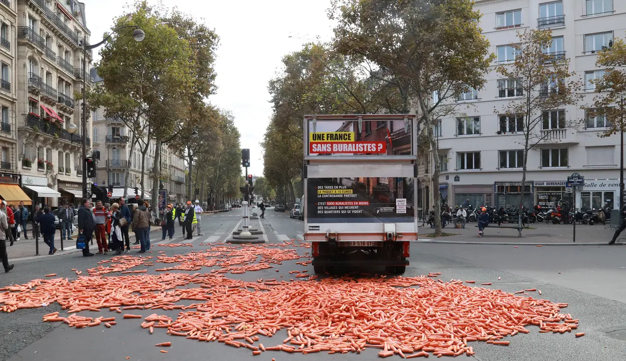 Sejumlah wortel berserakan di depan kantor Kementerian Kesehatan di Paris, Rabu (4/10). Peserta aksi gunakan wortel sebagai alat protes karena warna oranye pada wortel menjadi simbol bagi penjual tembakau atau rokok di Paris. (AFP PHOTO/JACQUES DEMARTHON)