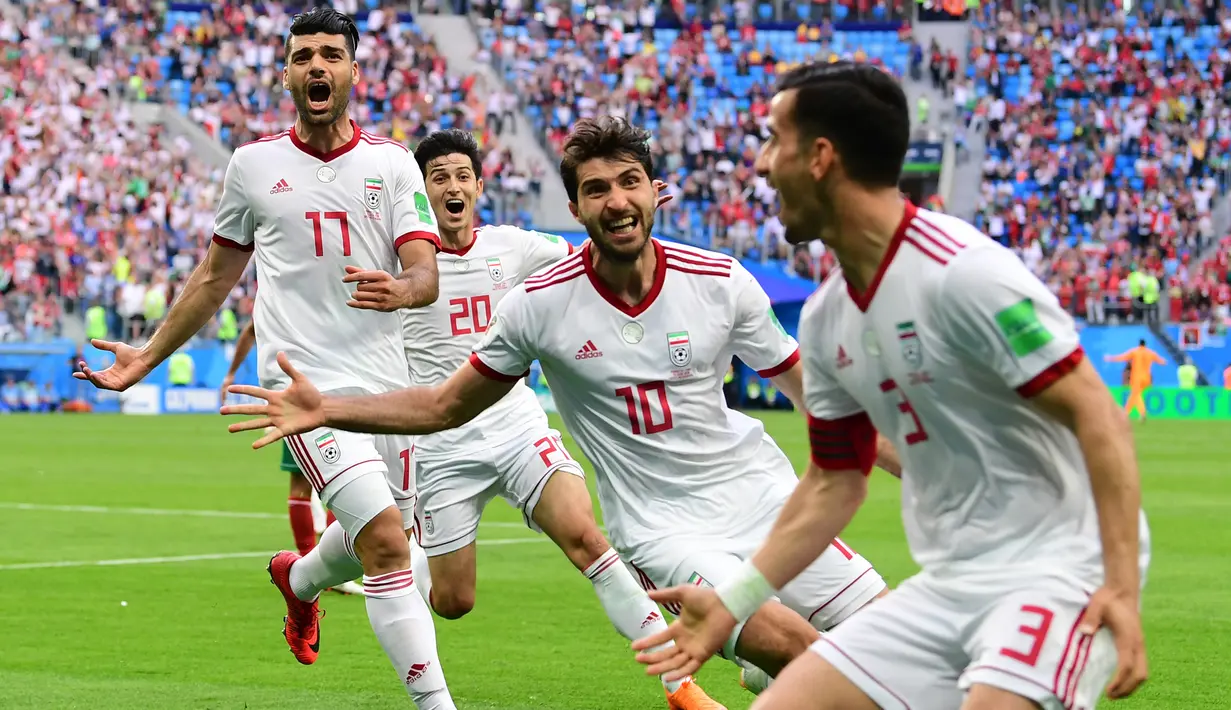 Para pemain Iran merayakan gol bunuh diri yang dilakukan pemain Maroko, Aziz Bouhaddouz, pada grup B Piala Dunia di Saint Petersburg, Jumat (26/6/2018). Gol ini tercipta pada menit ‘90+5 atau masa injury time. (AFP/Giuseppe Cacace)