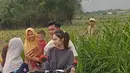Dibonceng Arhan depan naik motor, Azizah pun tampil dengan rambut diikat belakang dengan makeup naturalnya. Ia pun melayani para ibu-ibu untuk selfie. [@tr.iyono390]