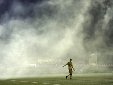 Asap flare yang dinyalakan suporter masuk ke dalam lapangan saat laga Sutton United melawan Arsenal pada putaran kelima Piala FA di Gander Green Lane stadium, London, (20/2/2017). Arsenal menang 2-0. (AP/Matt Dunham)