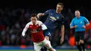 Gelandang Arsenal, Mesut Ozil dihentikan Nemanja Matic pada laga lanjutan Premier League yang berlangsung di Stadion Emirates, London, Minggu (10/3). Arsenal menang 2-0 atas Man United. (AFP/Ben Stansall)