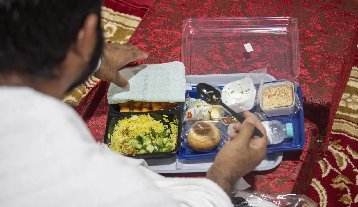<p>Jemaah makan dalam kamp saat melaksanakan rangkaian ibadah haji di Kota Suci Makkah, Arab Saudi, Kamis (30/7/2020). Hanya sekitar seribu jemaah yang diizinkan untuk melakukan ibadah haji tahun ini karena pandemi COVID-19. (Saudi Ministry of Media via AP)</p>