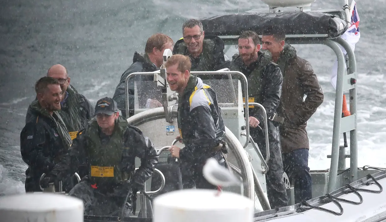 Pangeran Harry menaiki sebuah kapal boat di bawah rintikan hujan, usai menghadiri jumpa pers di Sydney Harbour di Australia, (7/6). Invictus Games merupakan pekan olahraga internasional yang dibuat oleh Pangeran Harry. (AP Photo/Rick Rycroft)