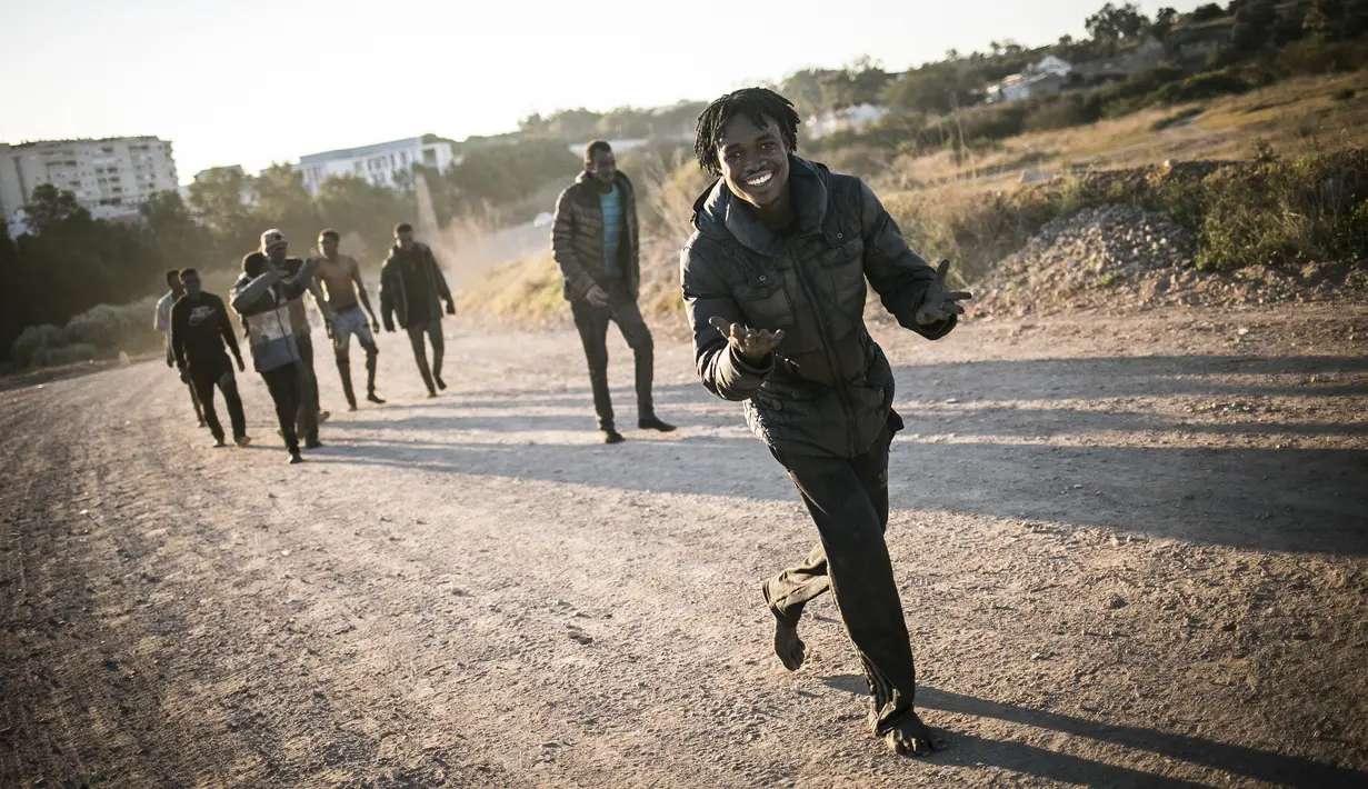 Para migran berlarian setelah melintasi pagar yang memisahkan daerah kantong Spanyol Melilla dari Maroko, di Melilla (3/3/2022). Pemerintah Spanyol di Melilla mengatakan 380 dari 1.200 migran berhasil mengatasi penghalang ganda 6 meter (20 kaki) yang mengelilingi kota. (AP Photo/Javier Bernardo)