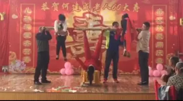 Seorang wanita di Cina menunjukkan kekuatan kakinya dengan mengangkat beberapa orang secara bersamaan