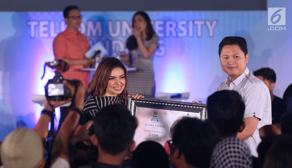 Duta baca Indonesia, Najwa Shihab (kiri) menerima cenderamata dari perwakilan Emtek, Iwan Triono pada gelaran Emtek Goes To Campus 2017 di Universitas Telkom, Bandung, Rabu (29/11). (Liputan6.com/Helmi Fithriansyah)
