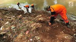 Sejumlah petugas PPSU atau pasukan oranye memunguti rumput liar dan sampah mengendap di tepi kali Ciliwung, Lenteng Agung , Jakarta, Sabtu (28/10). Hal tersebut dilakukan demi menjaga kebersihan kali Ciliwung. (Liputan6.com/Helmi Afandi)