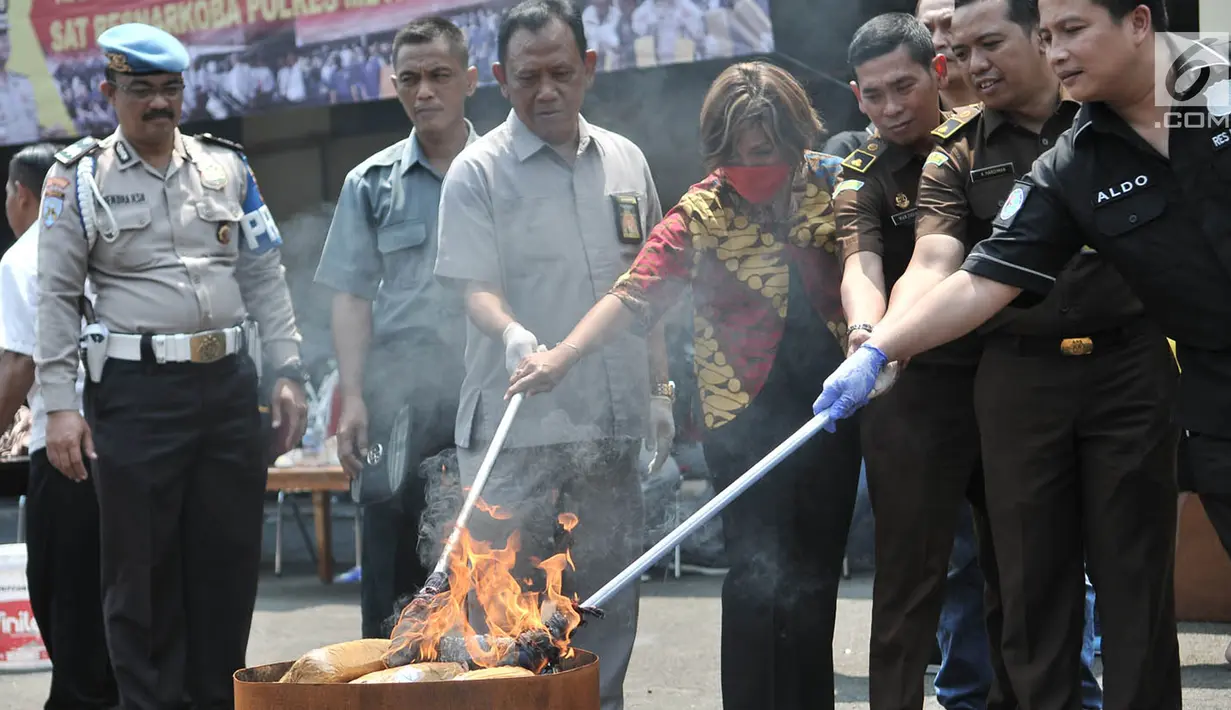 Petugas Satresnarkoba memusnahkan barang bukti ganja dengan cara dibakar di Halaman Polres Jakarta Utara, Rabu (28/3). Narkoba yang disita dari 6 tersangka itu merupakan hasil pengungkapan dari Januari - Februari 2018. (Merdeka.com/Iqbal S. Nugroho)