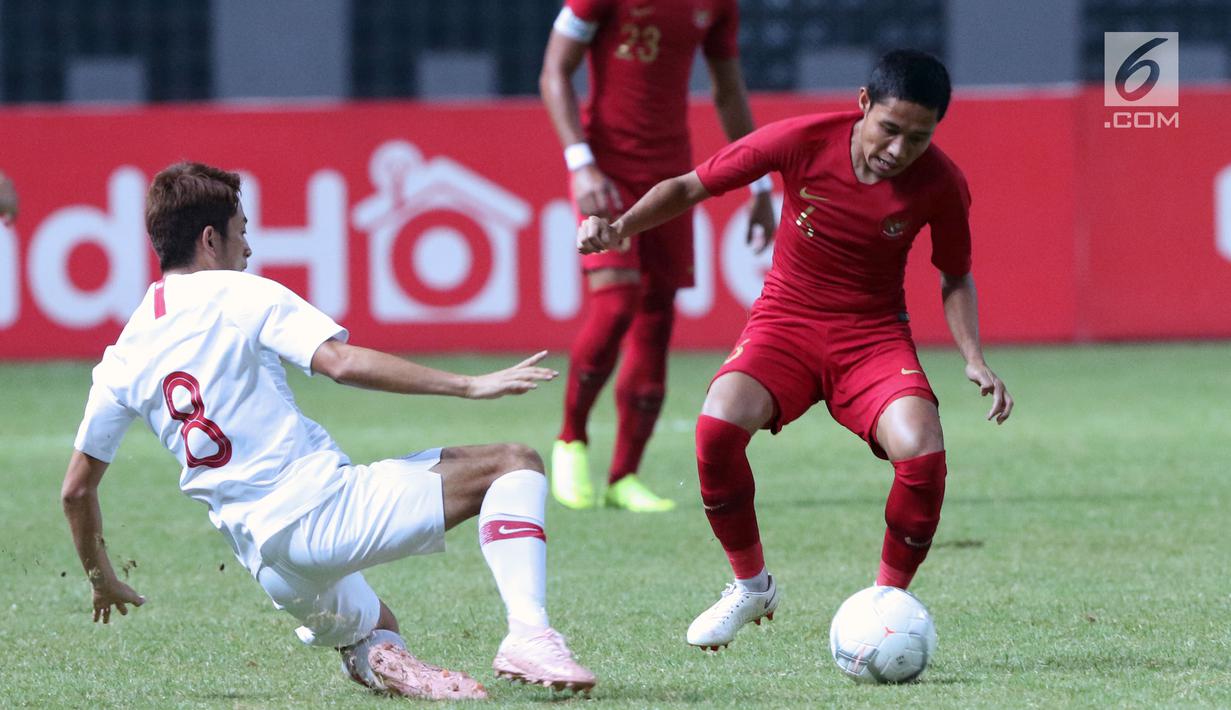 Pemain Timnas Indonesia, Evan Dimas Darmono (kanan) berebut bola dengan pemain Hong Kong pada laga uji coba internasional di Stadion Wibawa Mukti, Cikarang, Selasa (16/10). Babak pertama, Indonesia unggul 1-0. (Liputan6.com/Helmi Fithriansyah)