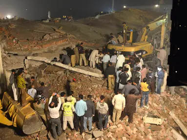 Tim SAR mencari korban di reruntuhan pabrik berlantai lima yang ambruk di Lahore, Pakistan Timur, Rabu (4/11) malam waktu setempat. Sedikitnya 16 orang tewas dan 40 luka-luka akibat kejadian tersebut. (AFP PHOTO/Arif Ali)