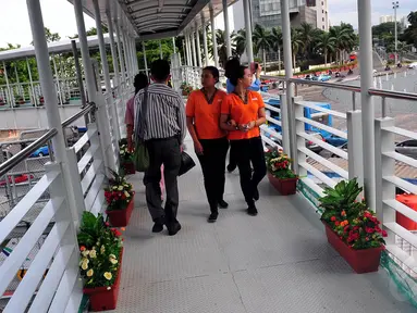 Sejumlah warga melintasi Jembatan Penyeberangan Orang (JPO) yang dihiasi dengan tanaman di Bundaran HI, Jakarta, Rabu (3/12/2014). (Liputan6.com/Johan Tallo)