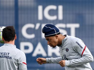 Penyerang Paris Saint-Germain (PSG) Kylian Mbappe (kanan) menyundul bola saat sesi latihan di tempat latihan klub Camp des Loges di Saint-Germain-en-Laye, barat Paris, Kamis (28/4/2022). Juara Ligue 1 yang baru dinobatkan PSG akan dijamu oleh Strasbourg pada pekan ke-35 Ligue 1 2021/22, Sabtu 30 April 2022, di Stade de la Meinau. (FRANCK FIFE / AFP)
