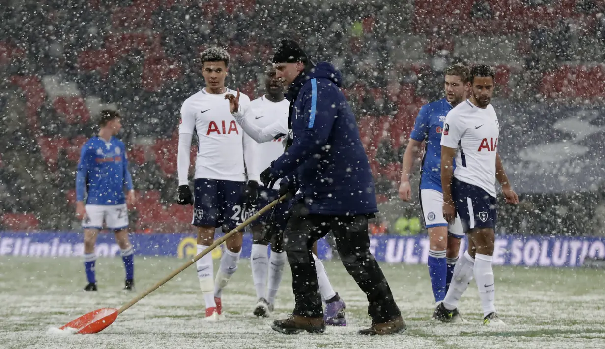 Seorang petugas membersikan salju dari alapangan saat babak kelima Piala FA antara Tottenham Hotspur melawan Rochdale di Wembley stadium, London, (28/2/2018). Tottenham menang 6-1. (AP/Matt Dunham)